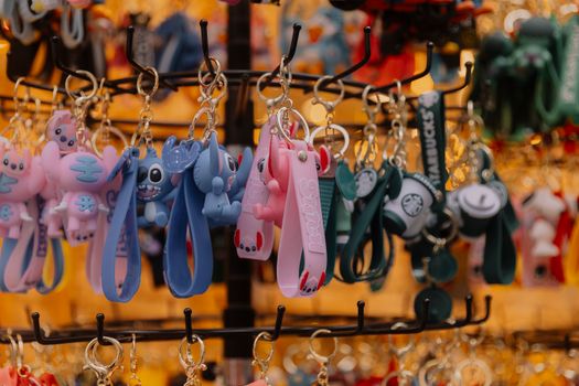Vibrant assortment of keychains with cartoon characters and themes in a souvenir shop.
