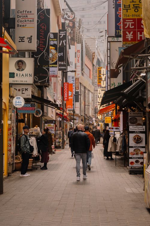 Free Vibrant Asian street scene filled with people and colorful signs. A lively marketplace atmosphere. Stock Photo