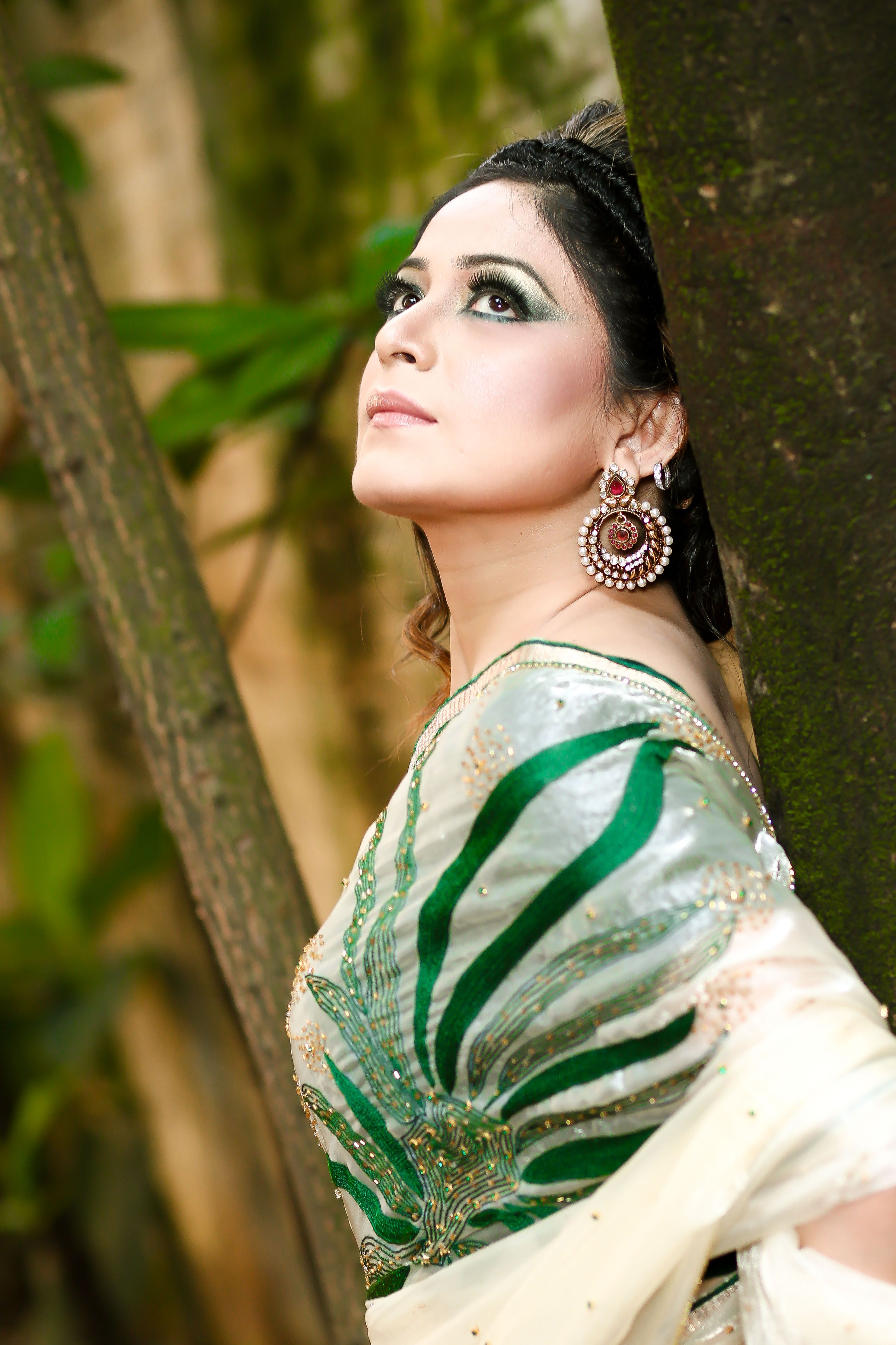 A woman in a green and white sari posing for the camera · Free Stock Photo