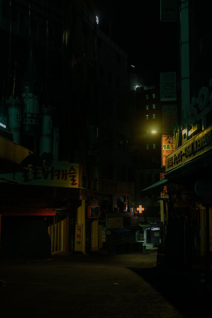 Empty city alley lit by neon signs at night — photo by Elina Volkova on Pexels