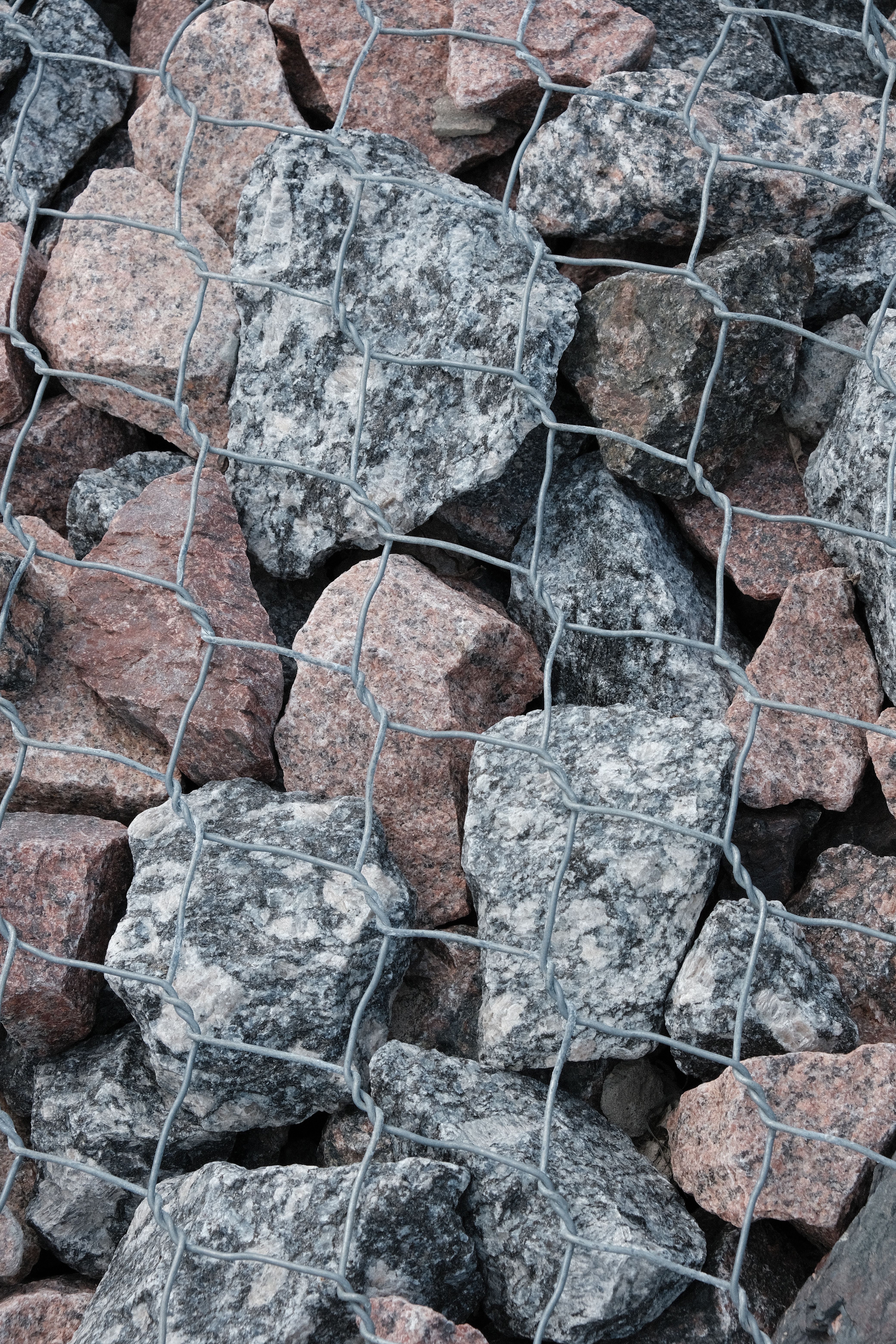 Close-up of Rock Wall with Wire Fencing · Free Stock Photo