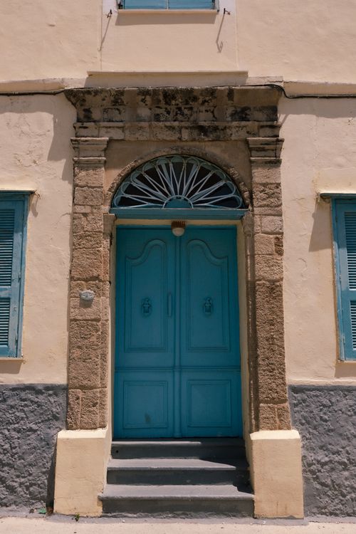 Free Elegant blue door set in a historic stone facade with arch detail. Stock Photo