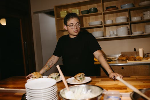 Chef working in a modern kitchen preparing sandwiches with fresh ingredients.