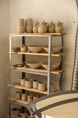Studio shelves stacked with greenware — photo by Enes Beydilli on Pexels