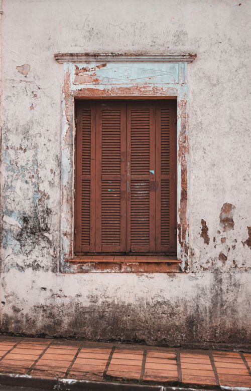 Free A rustic, weathered window with shutters on a distressed wall in Júlio de Castilhos, Brazil. Stock Photo