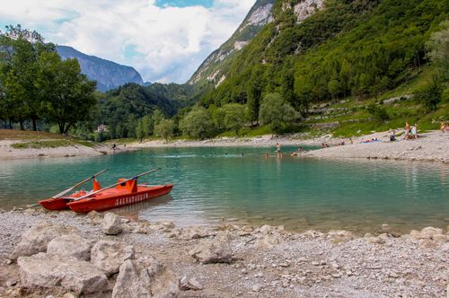 Free A tranquil summer scene with boats on a lake surrounded by mountains and lush greenery. Stock Photo