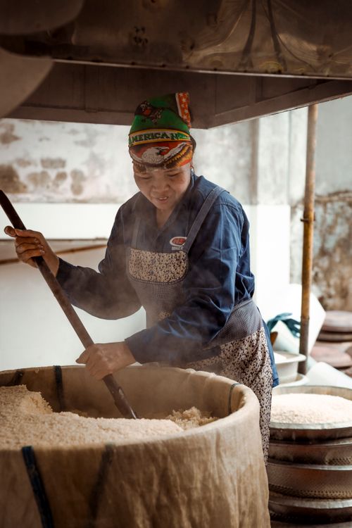 Free An artisan skillfully prepares rice in a traditional setting, showcasing culinary expertise. Stock Photo