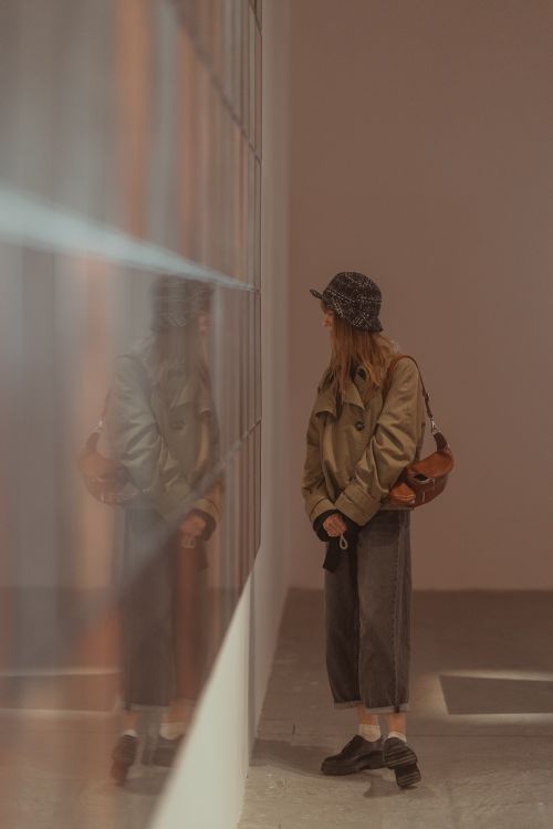 Free Woman admiring art in a Venice museum with stylish fashion and reflections. Stock Photo