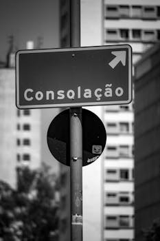 Monochrome photograph of Consolação street sign in an urban setting.