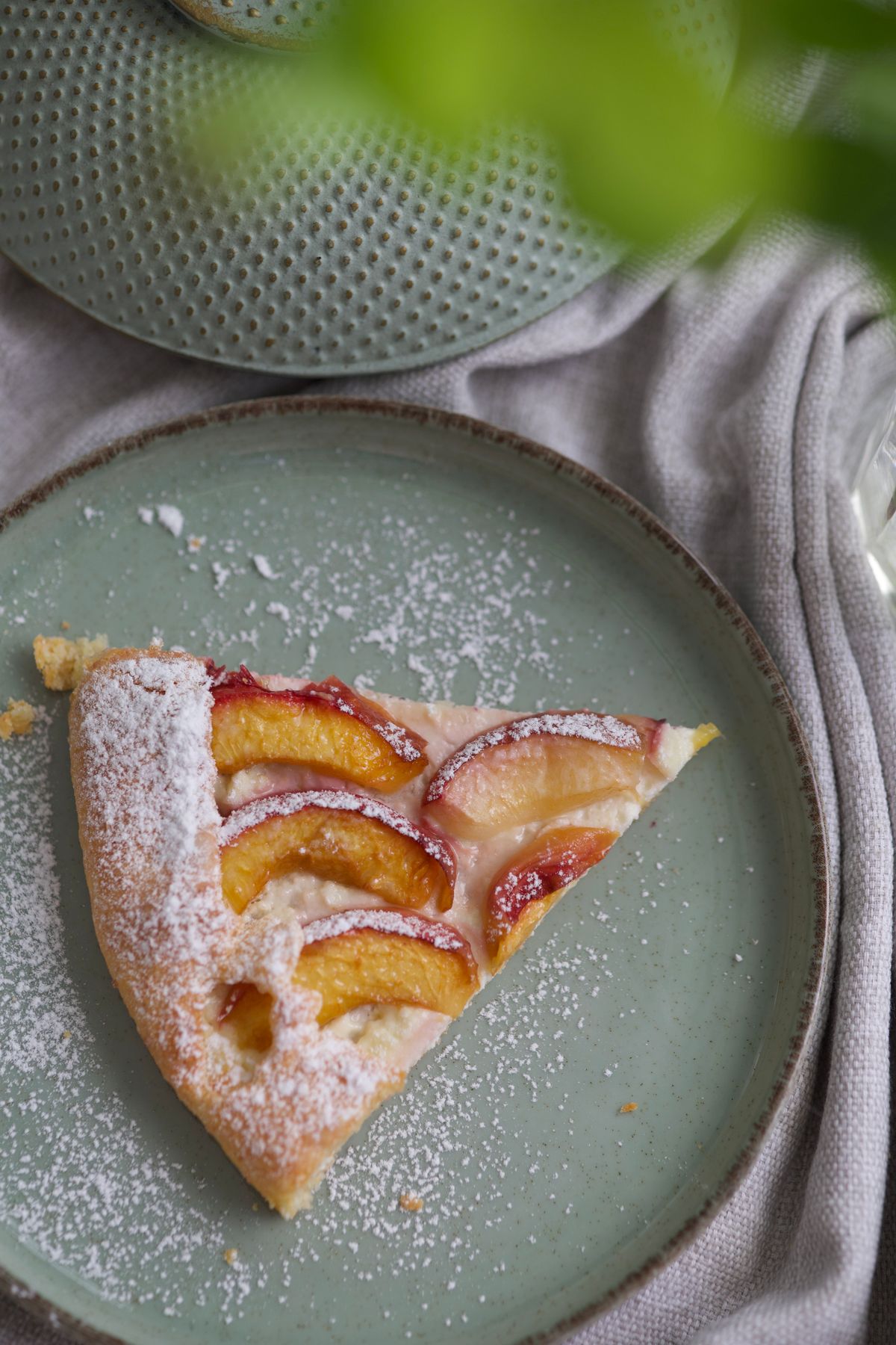 Apple pie slice on a plate dusted with icing sugar