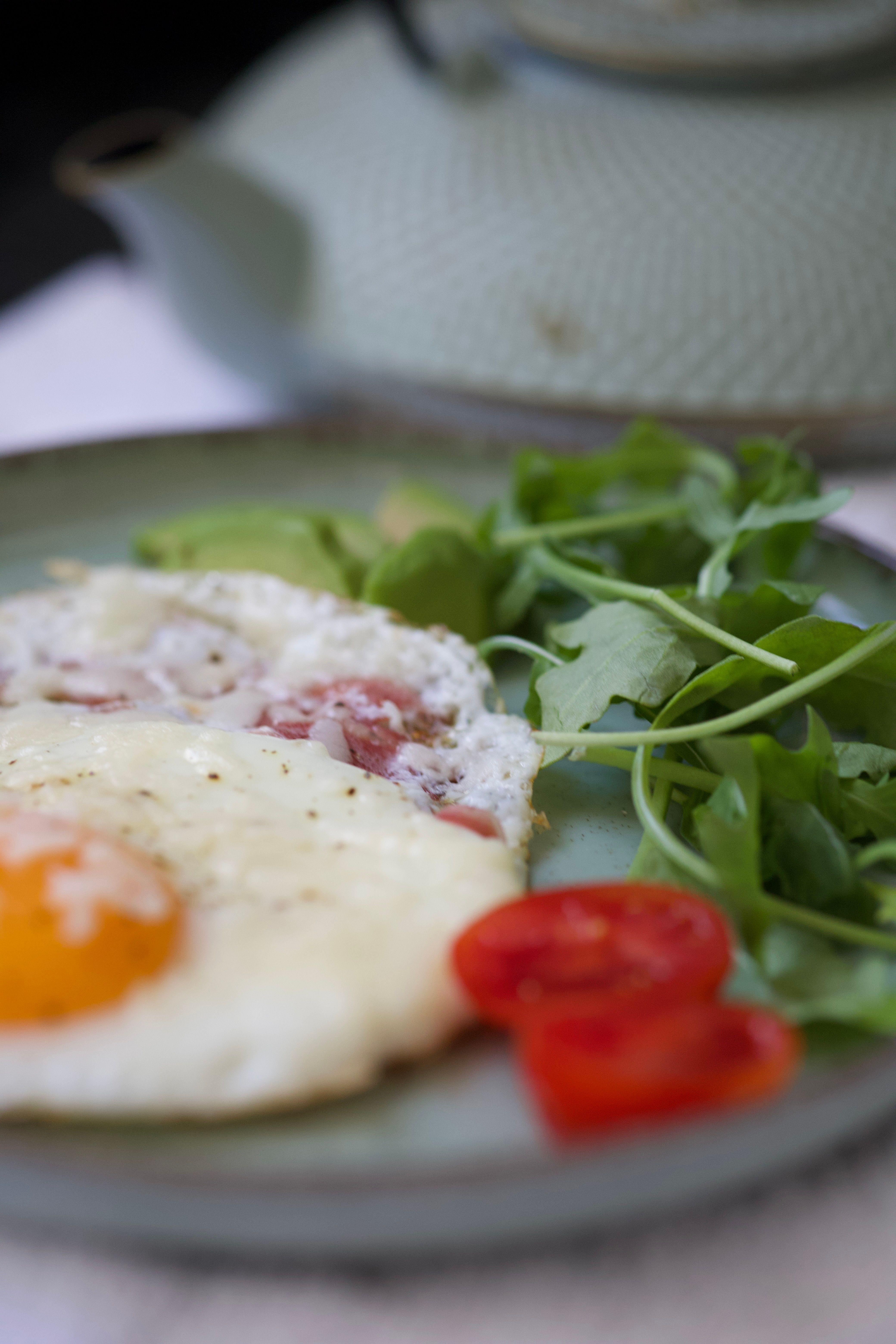 A delicious breakfast featuring fried eggs, arugula, and tomatoes on a plate.