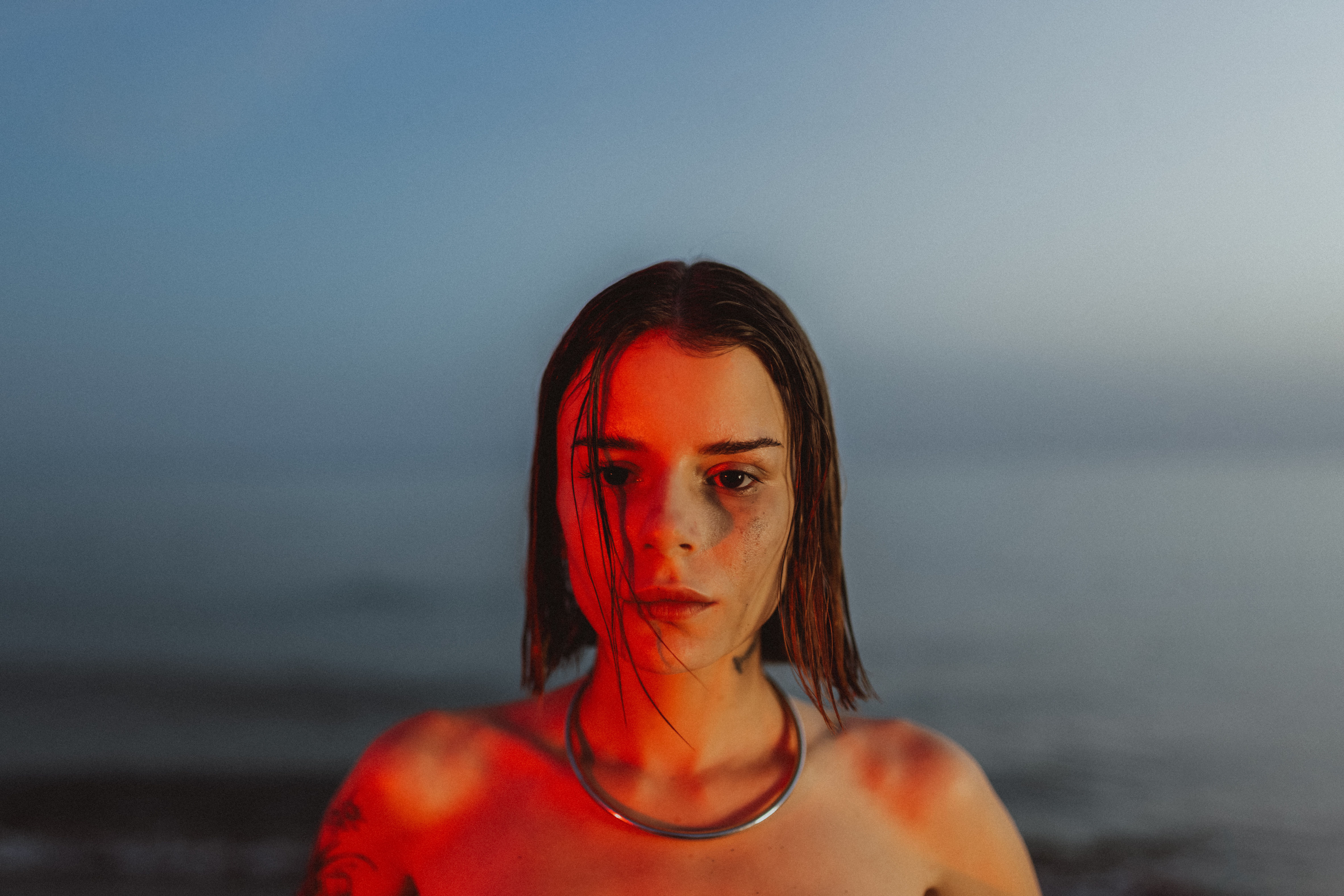 A Young Woman Standing on the Beach Illuminated with Red Light · Free ...