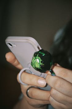 A woman holding a smartphone and a lollipop in Prague, Czechia.
