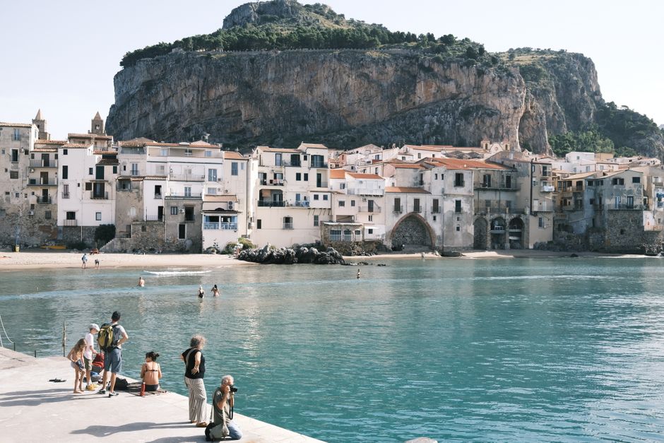 Charming coastal view of Cefalù, Sicily with historic buildings and clear waters.