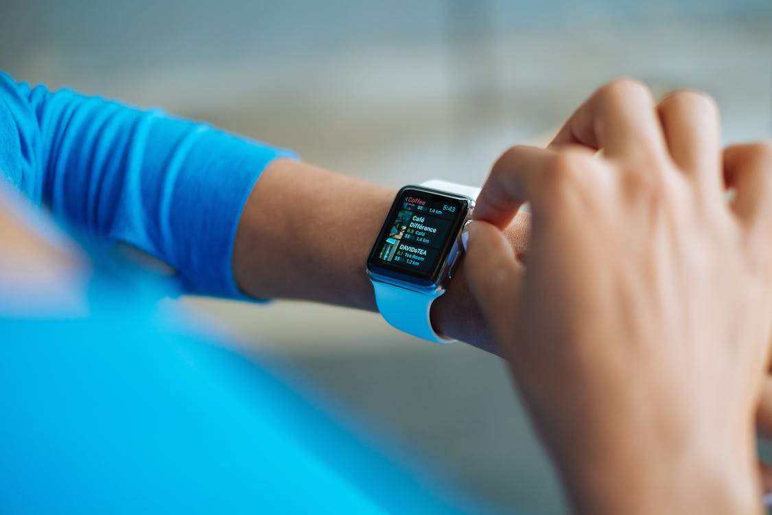 Free Person in Blue Long Sleeve Shirt Using Smart Watch Stock Photo