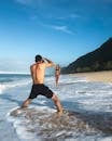 Man Taking Photo of Woman Standing on Shore