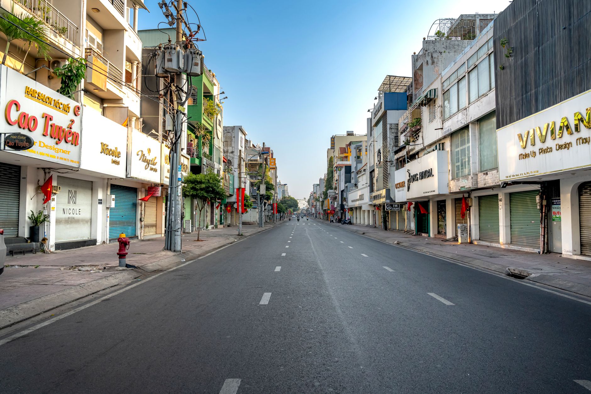 A quiet urban street in Vietnam with colorful buildings under a clear blue sky.