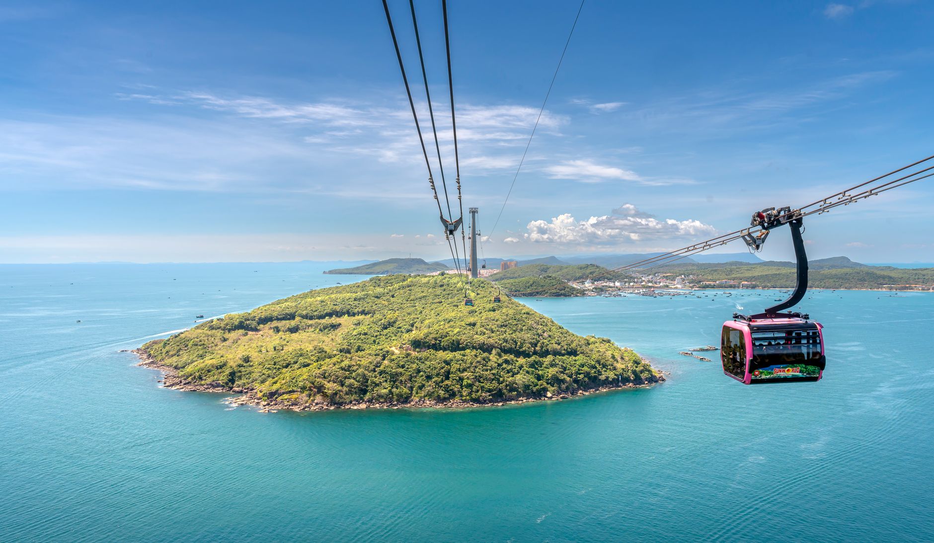 Stunning aerial view of a cable car crossing over Thom Island with clear blue waters in Vietnam.