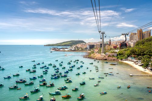 Free A breathtaking aerial view showcasing a vibrant coastline in Vietnam with cable cars and boats. Stock Photo