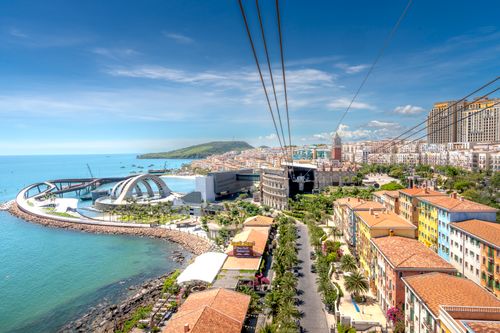 Free Vibrant coastal cityscape featuring modern architecture and blue seashore. Stock Photo
