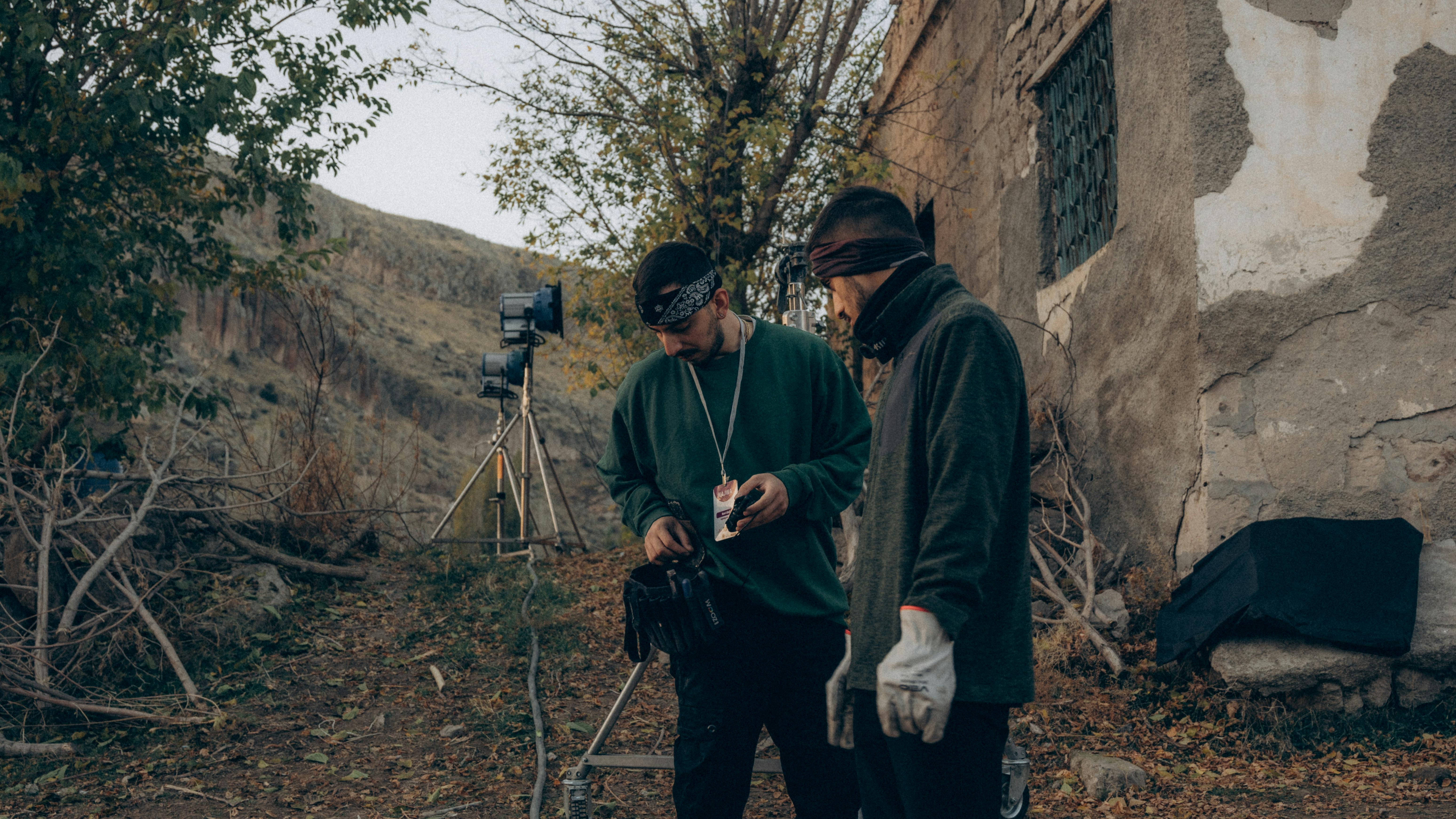 Film production crew with equipment near an abandoned building, Upper Midwest location