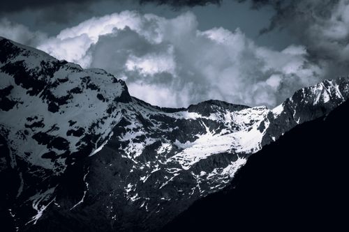Free A stunning view of snowcapped mountains with dramatic clouds above, evoking a sense of nature's raw beauty. Stock Photo