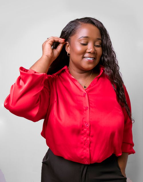 Free Portrait of a cheerful woman in a vibrant red shirt against a white background. Stock Photo