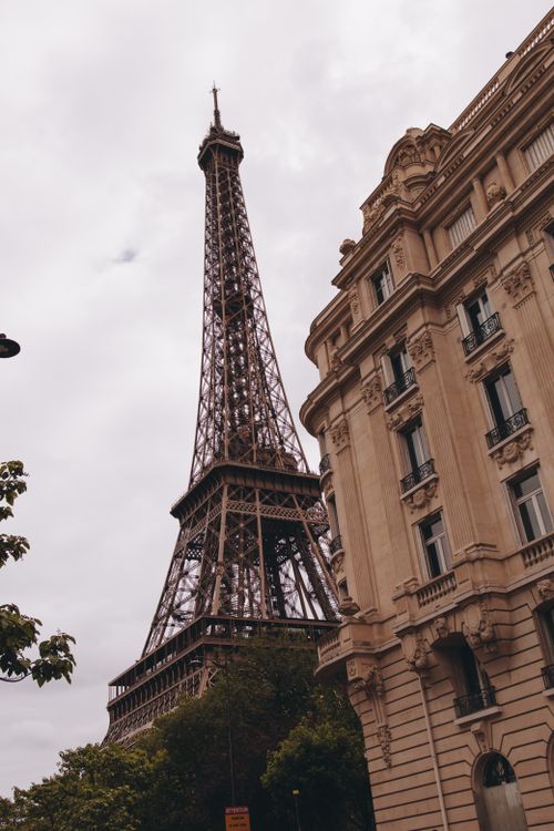 Free A beautiful view of the Eiffel Tower with classic Parisian architecture in the foreground. Stock Photo