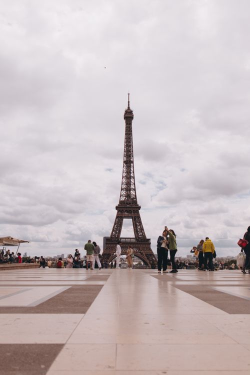 Free Scenic view of the Eiffel Tower with people gathering around in Paris, France. Stock Photo