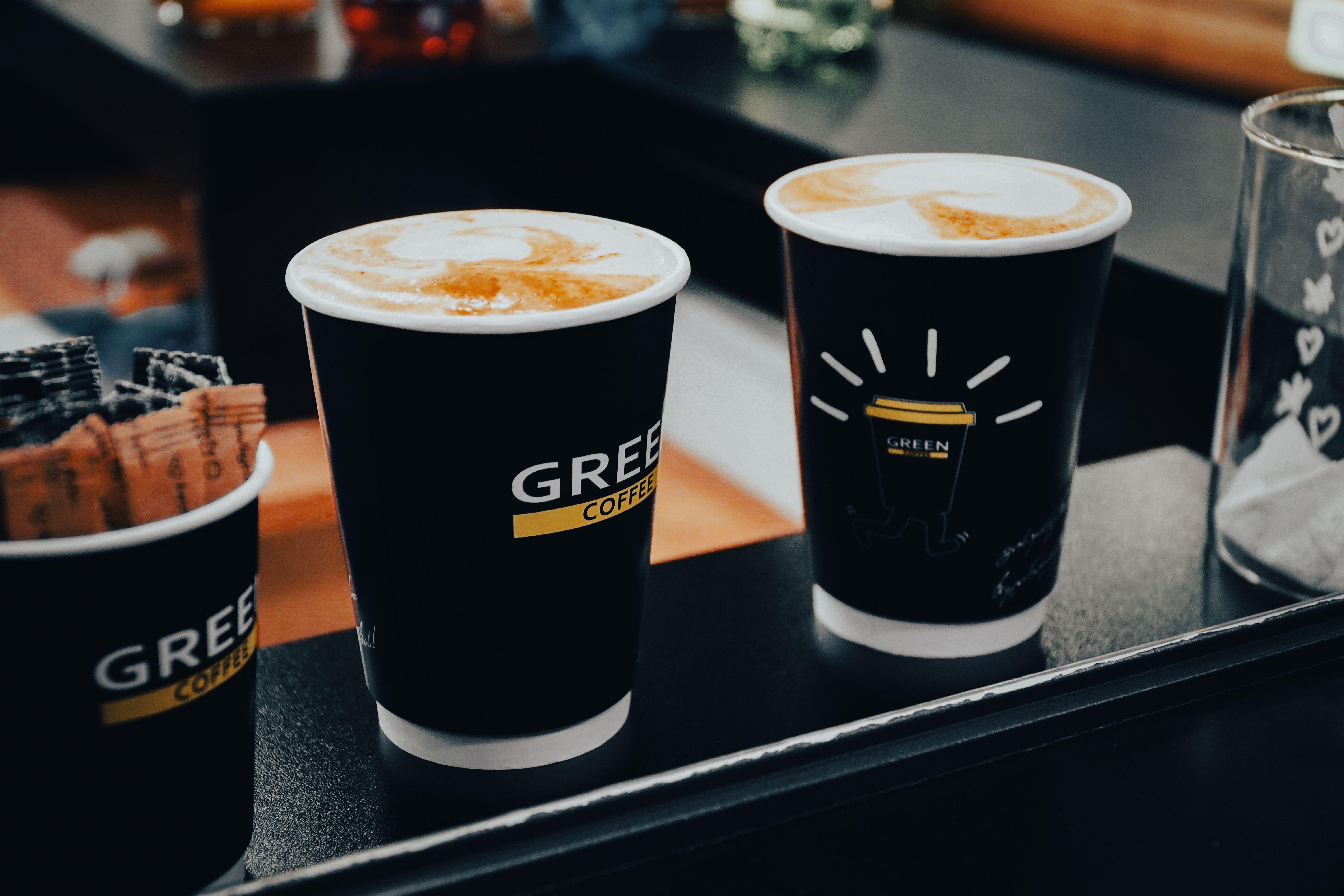 A person holding a white ceramic coffee cup with latte art on top