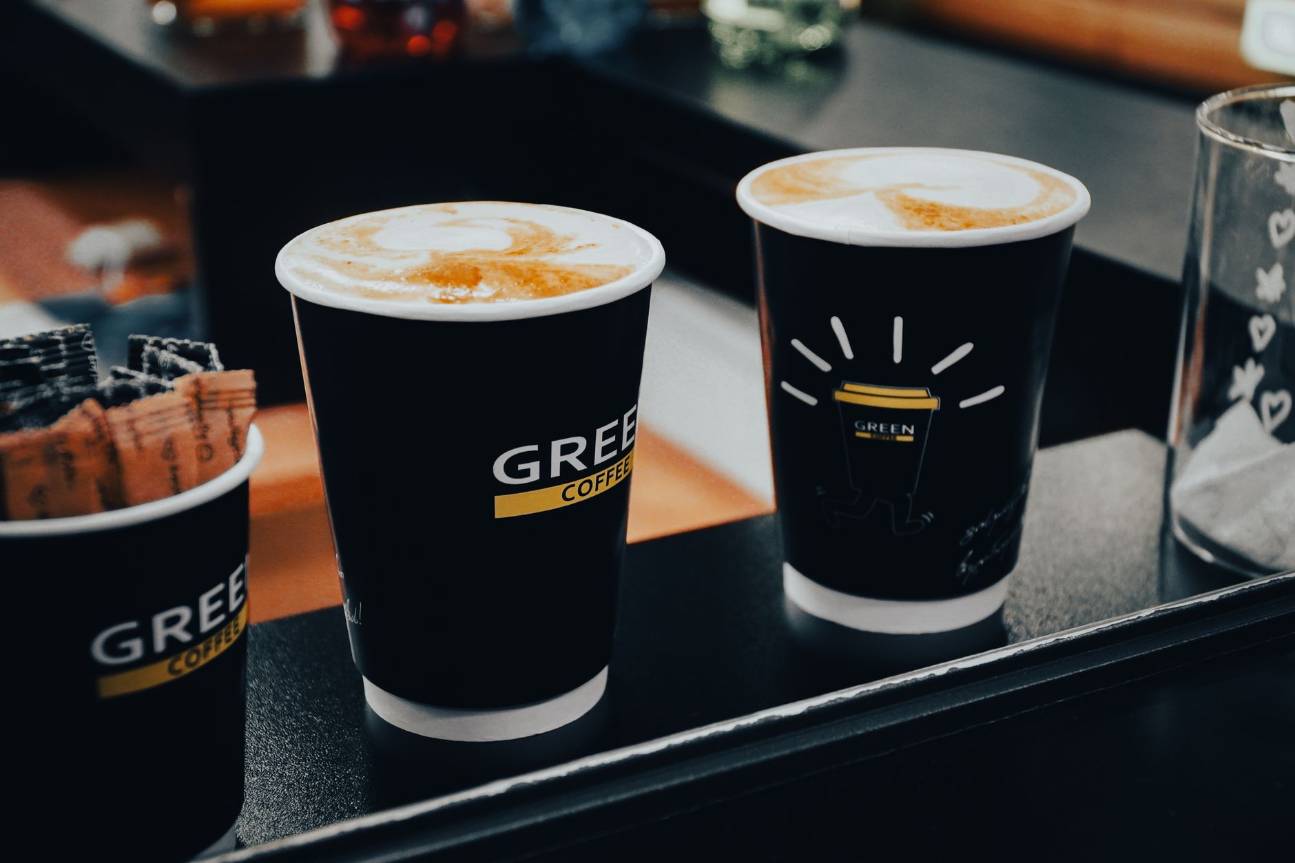 A person holding a white ceramic coffee cup with latte art on top
