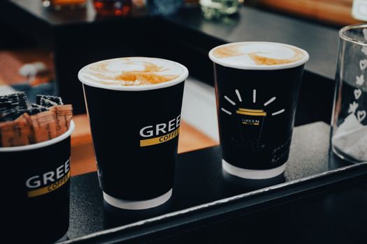 一杯热气腾腾的茶水放在桌面纸杯里的场景，旁边有产品说明标签