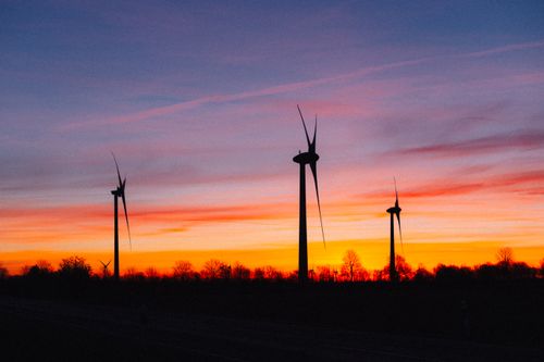 Free Silhouetted wind turbines against a vibrant sunset in rural Germany, showcasing renewable energy. Stock Photo