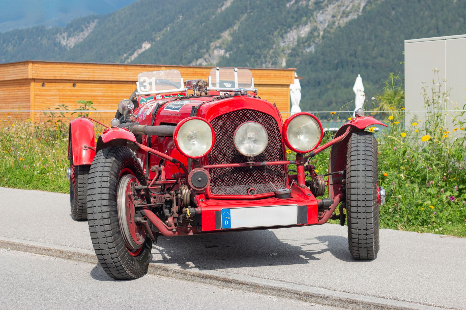Red classic sports car on a winding mountain road