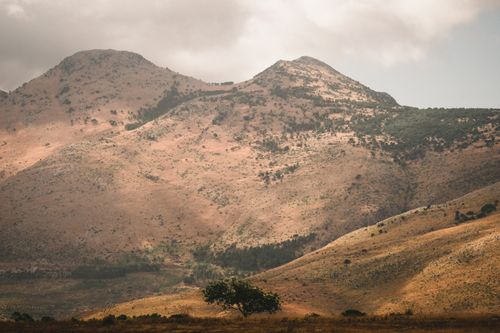 Free Serene mountain landscape with rolling hills under a cloudy sky. Stock Photo
