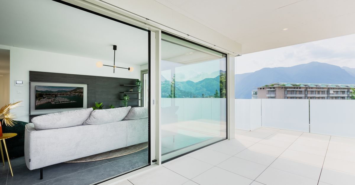 A stylish modern living space with a balcony offering a scenic mountain view.