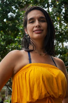 Smiling woman in yellow dress enjoying a sunny day outdoors in Mérida, Venezuela.