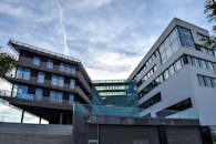 这座现代化的玻璃立面建筑，背靠蓝天，展现出创新的建筑特色