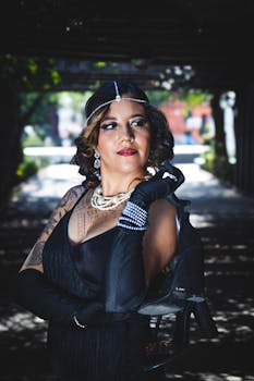 Elegant woman dressed in vintage evening attire with pearls and gloves, posing outdoors.