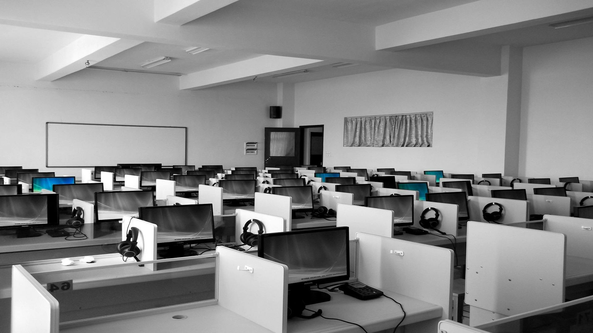 A spacious, empty call center office with rows of desks and computers, ideal for business environments.