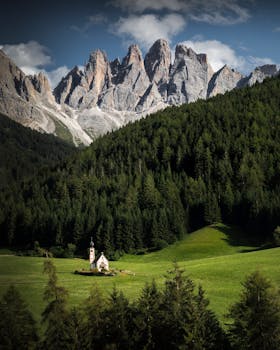 在郁郁葱葱的绿色森林中，一座风景如画的教堂坐落在雄伟的山峰上