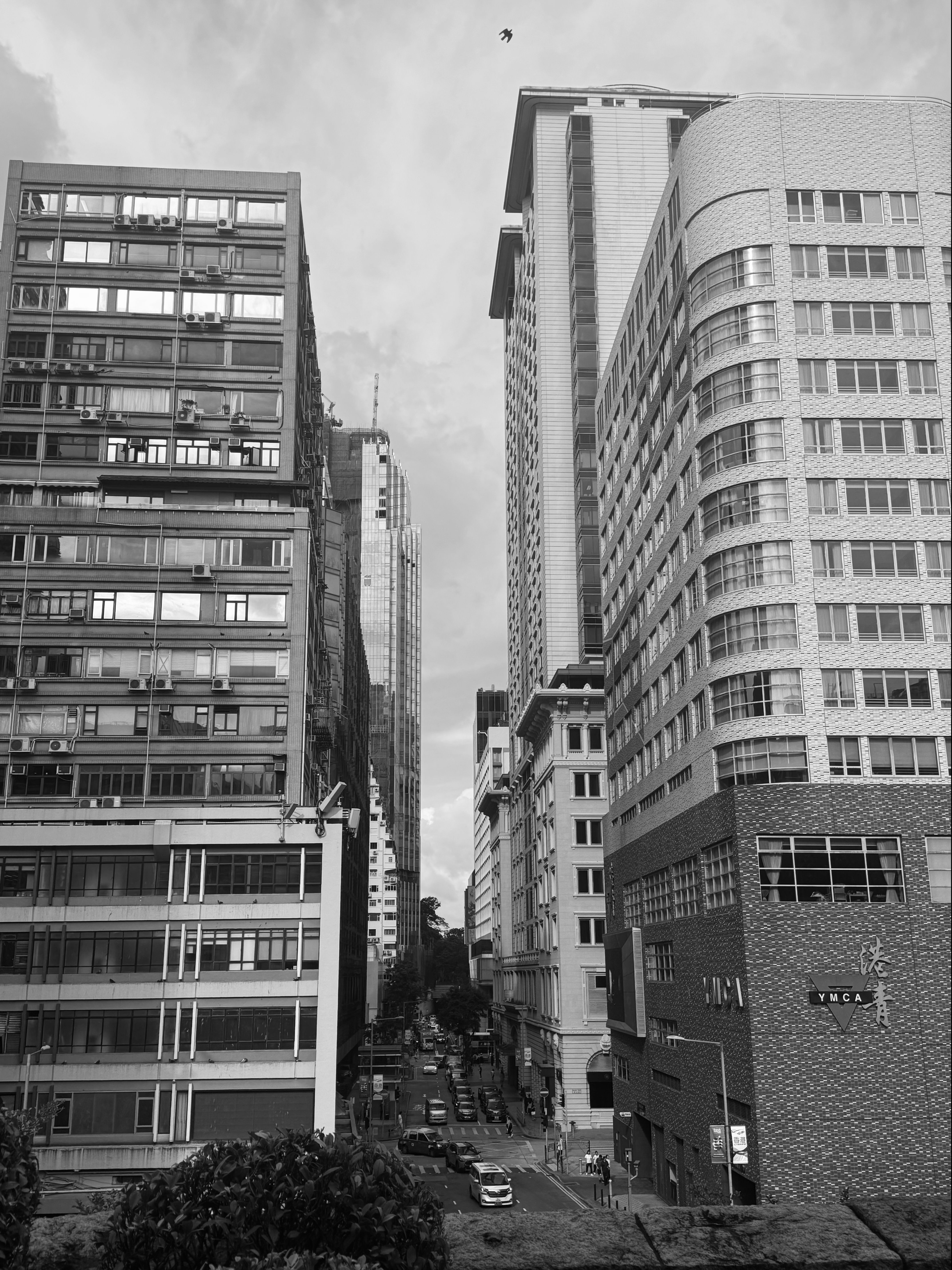 Captivating black and white cityscape featuring tall buildings and bustling street below.