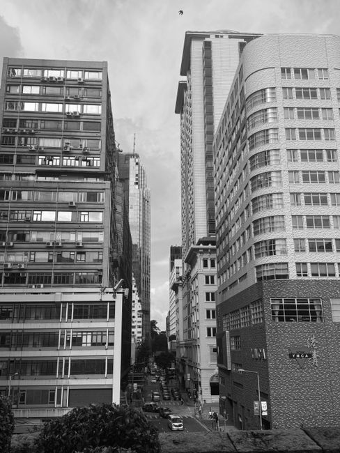 Captivating black and white cityscape featuring tall buildings and bustling street below.