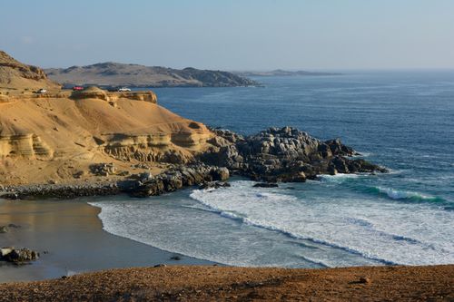 Free Stunning cliffside view of waves crashing on a rocky seashore at sunset. Stock Photo