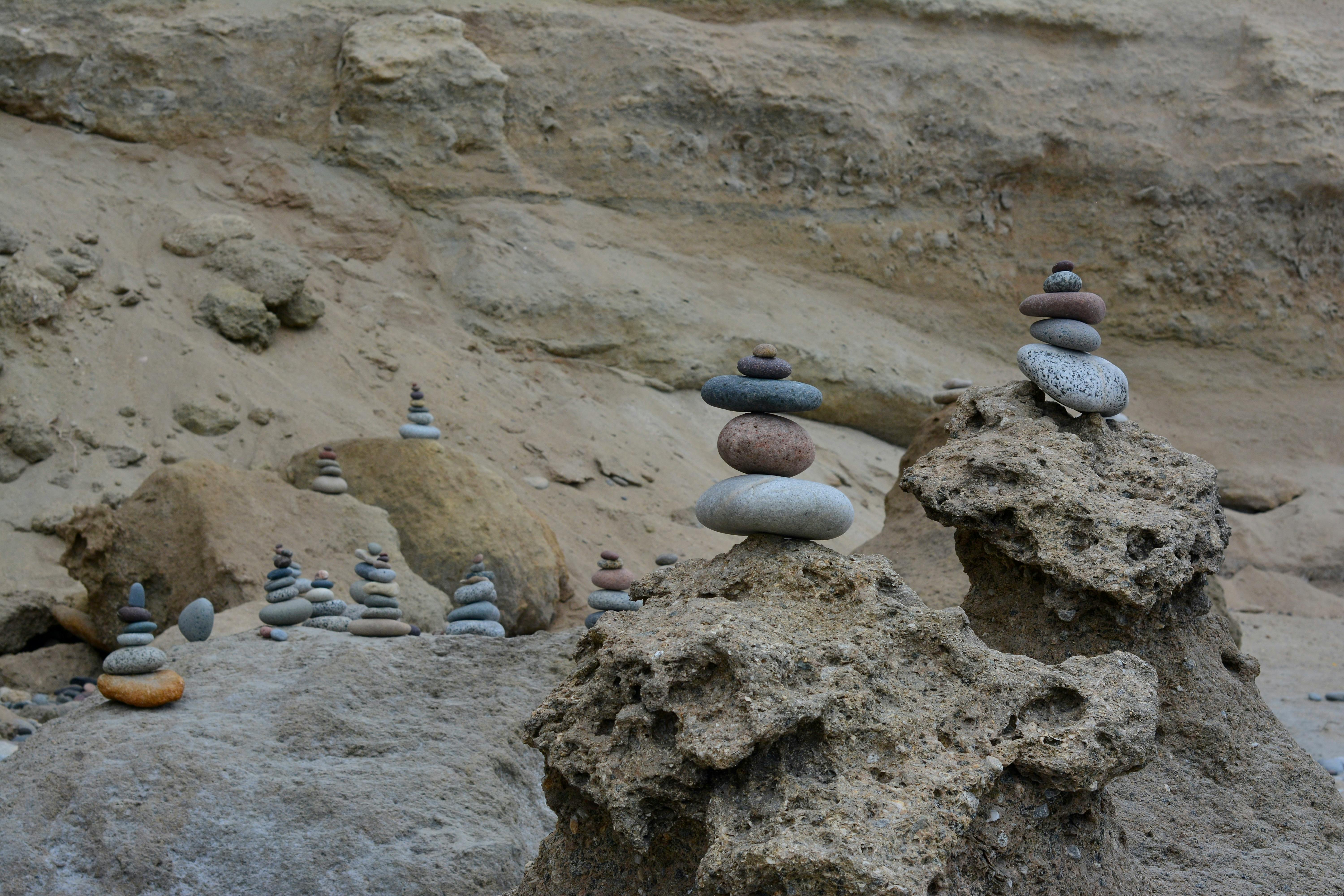 Stone stacks artfully balanced on rocky cliffs by the seaside, creating a tranquil scene.