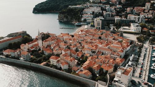 Free Experience the stunning aerial view of Budva's historic Old Town with its distinctive red roofs on the Adriatic coast. Stock Photo