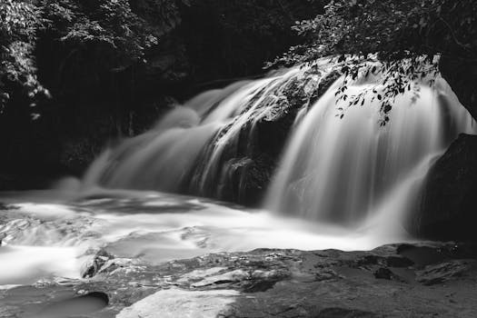 Black and white photo of a tranquil waterfall in Chiang Mai, Thailand, showcasing nature's beauty.