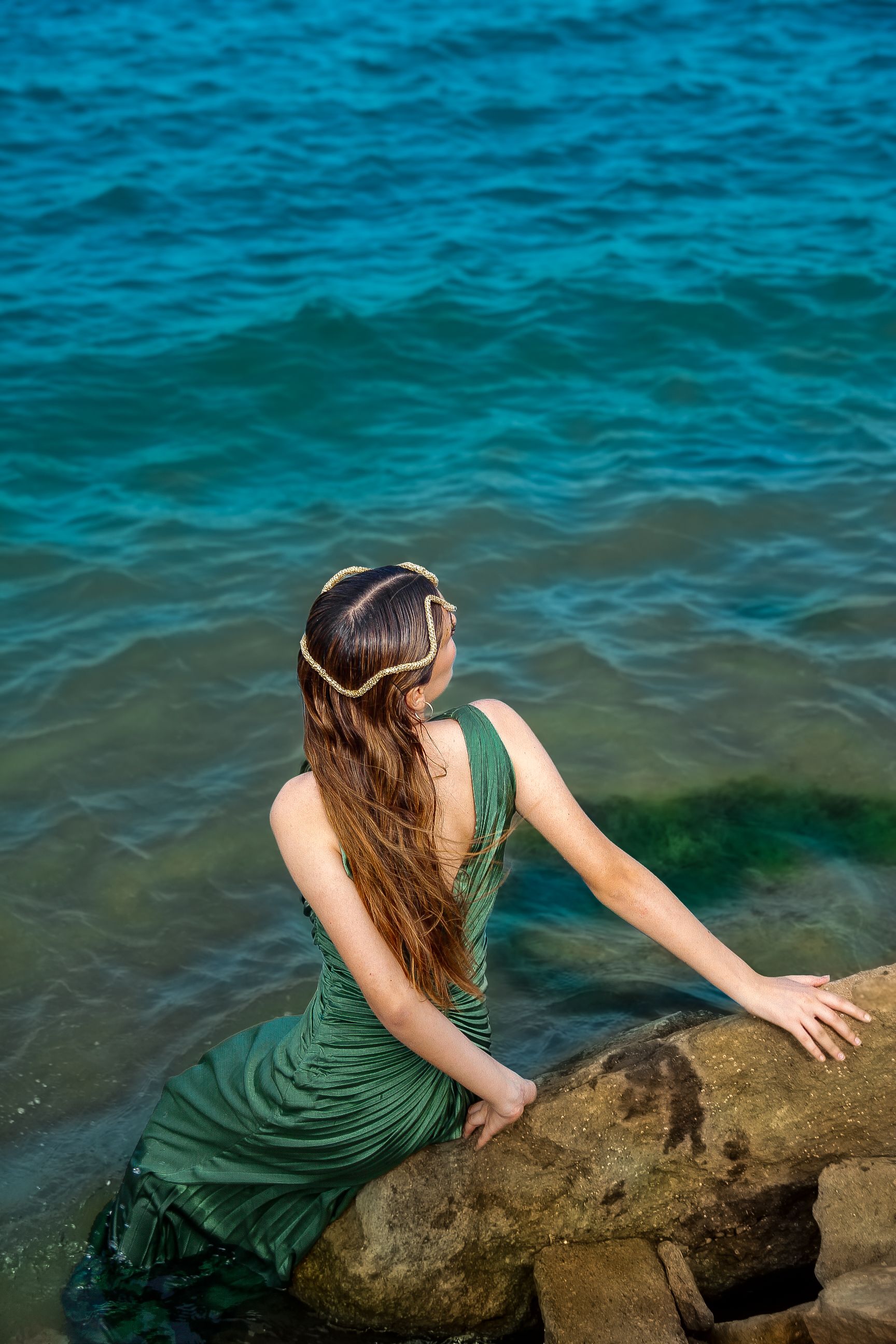 A Woman in a Green Dress Sitting on a Rock on the Shore · Free Stock Photo