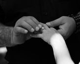 Crop groom putting wedding ring on finger of fiancee