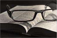 Black Eyeglasses Placed on White Book